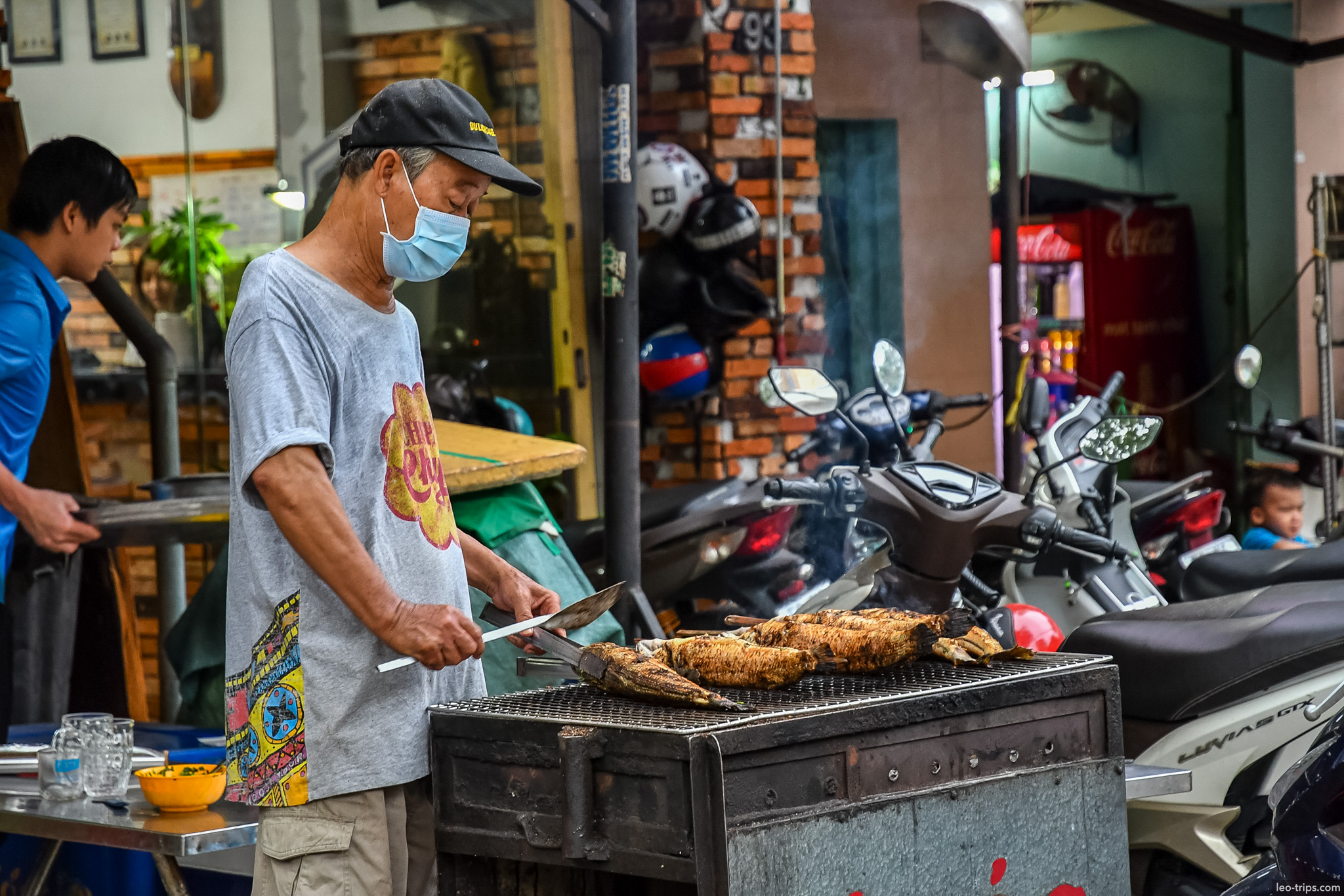 man grilling fish street food saigon ho chi minh city