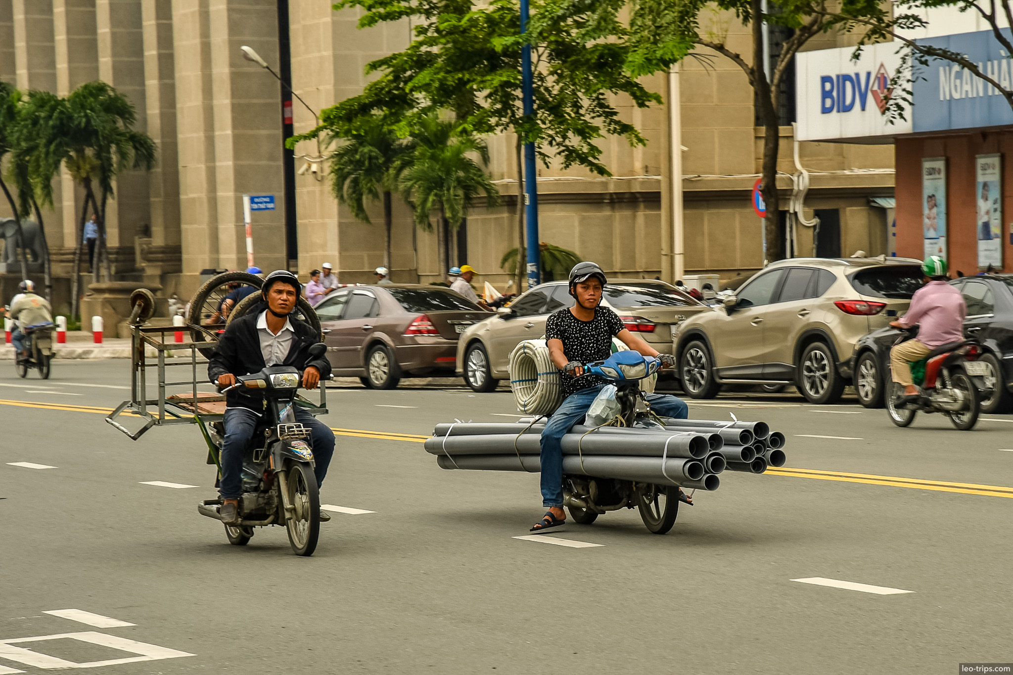 motorbikes carrying steel pipes saigon street ho chi minh city