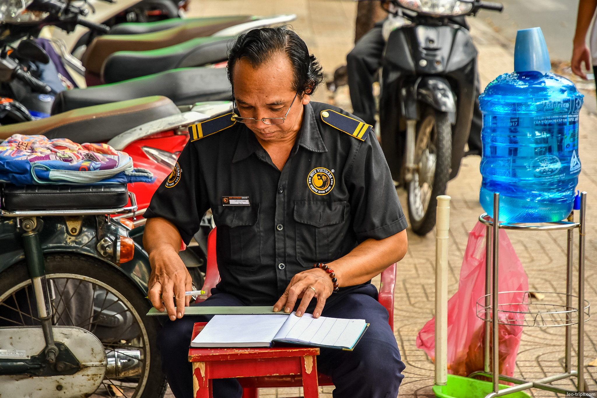 security guard reading notebook sidewalk ho chi minh city